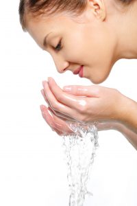A woman washing her face with water